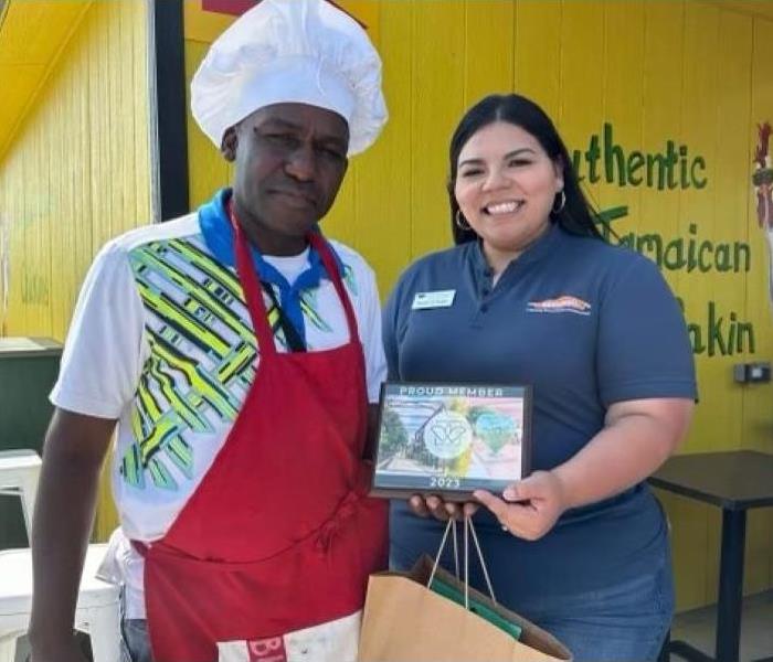 Female presenting Male in Chef's Hat with plaque