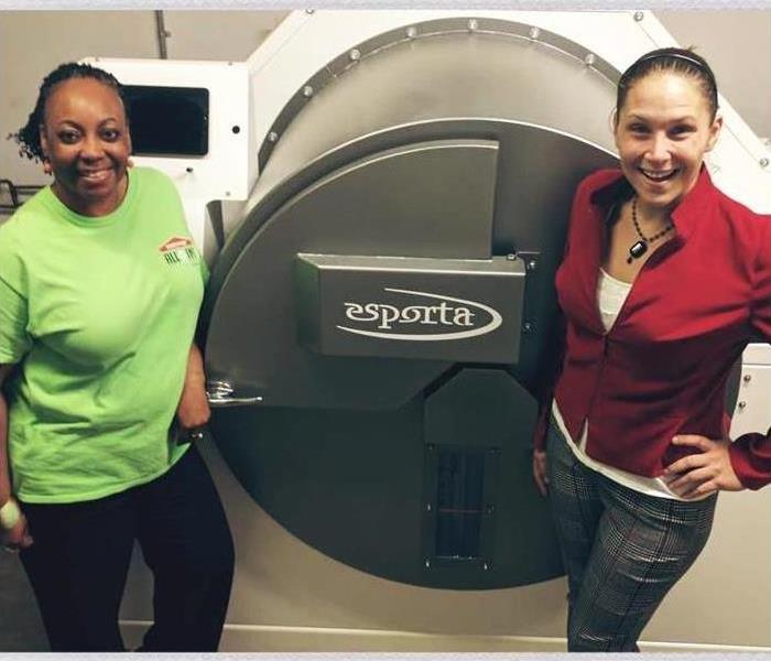 two female employees standing beside our esporta machine